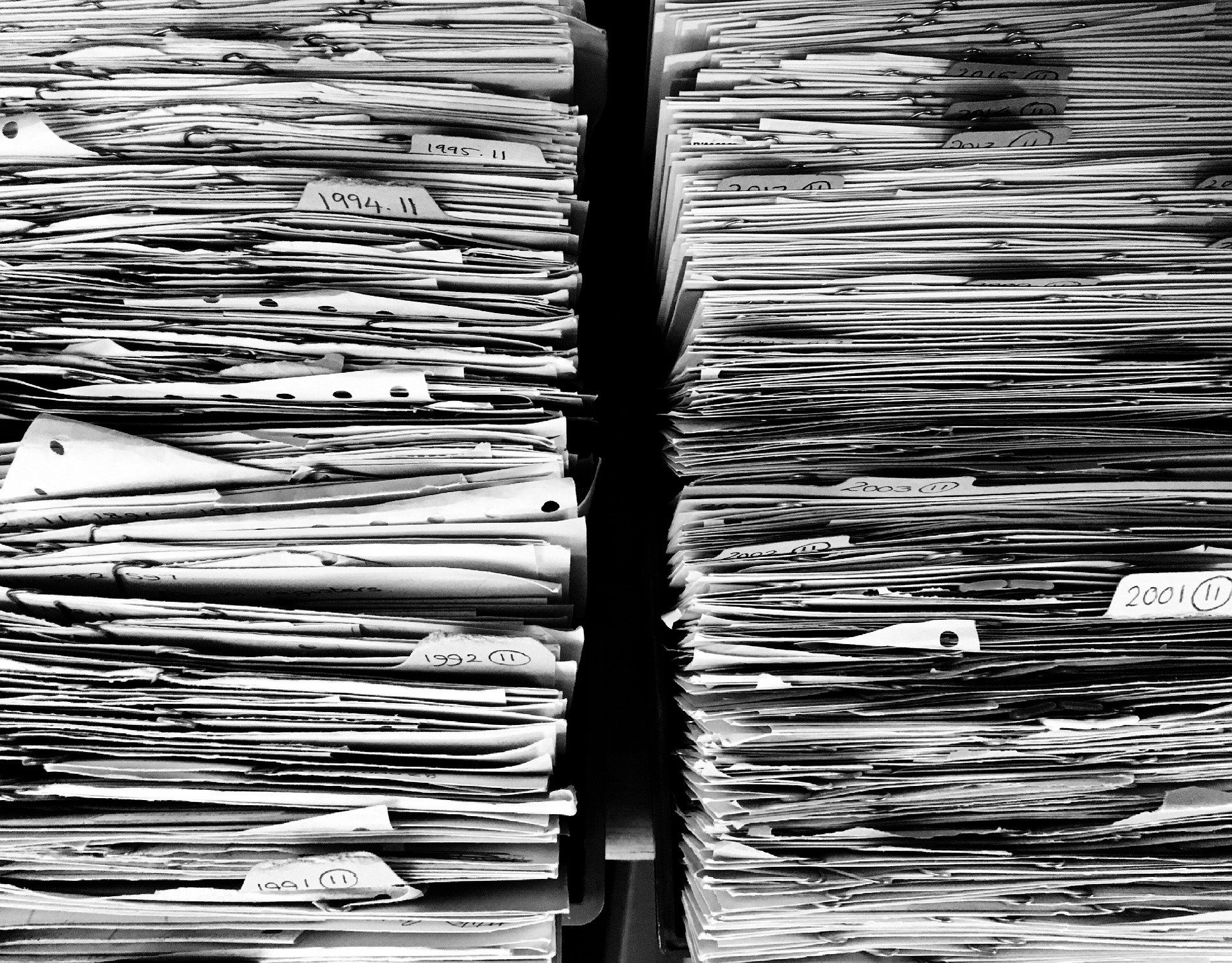 Stack of paperwork representing data protection, record keeping and compliance