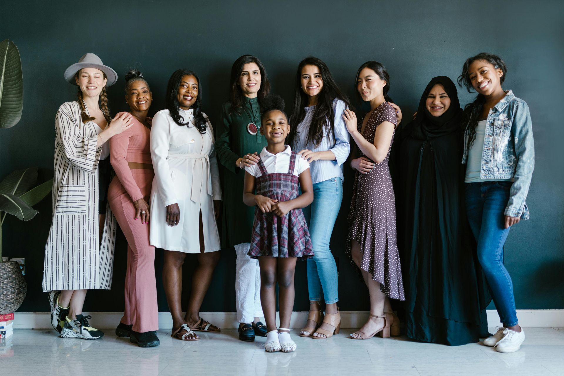 Group standing together indoors, smiling, with children and adults in coordinated outfits.