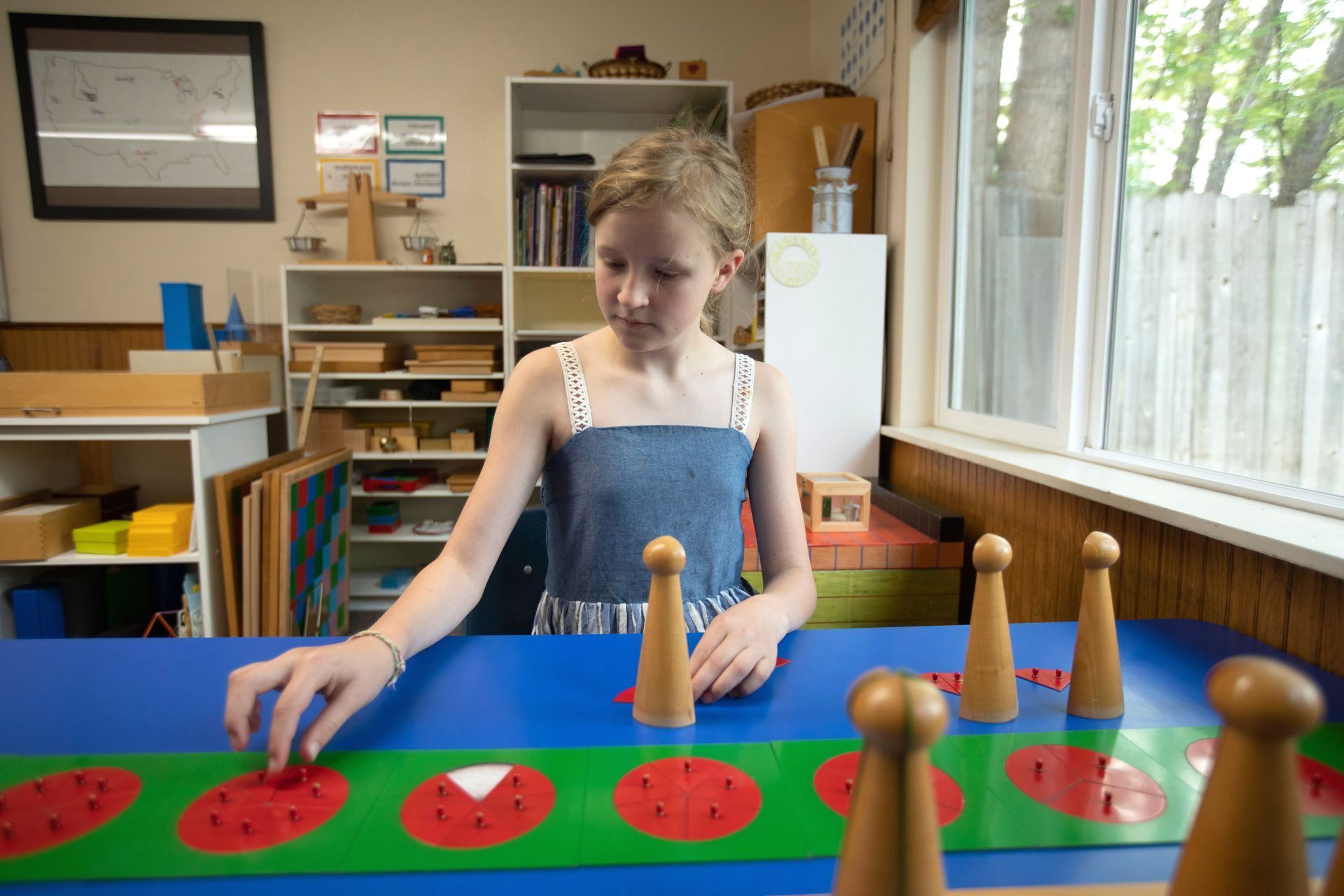 a young girl is playing with wooden toys on a table