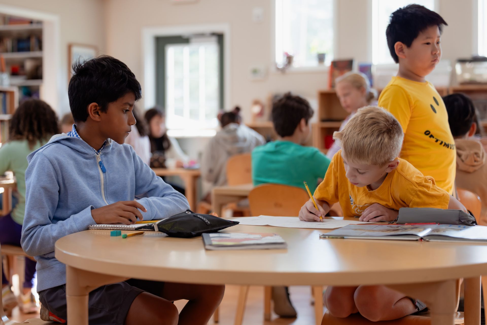 Children seated at tables working on school activities in a classroom