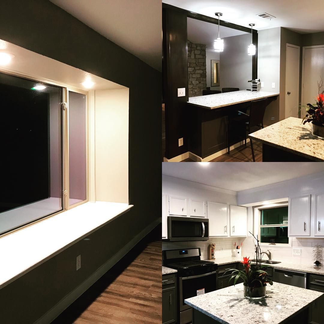Modern kitchen with dark cabinets, granite island, white cupboards, and wood floors; empty room