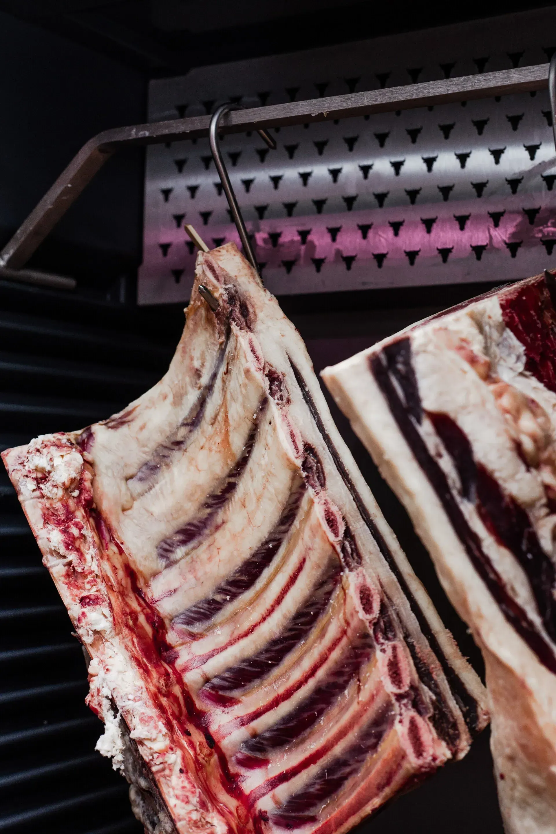 Ribs of Beef Hanging on a Hook, Showing Raw Meat and Bone — Lighthouse Meat & Poultry In Port Macquarie, NSW