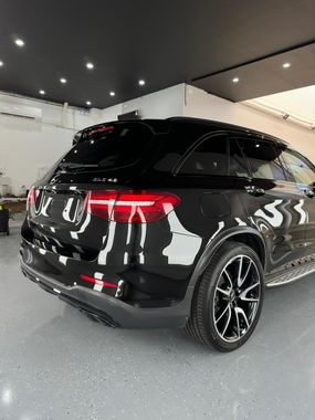 A black suv is parked in a customers garage with a new Ceramic window tints.