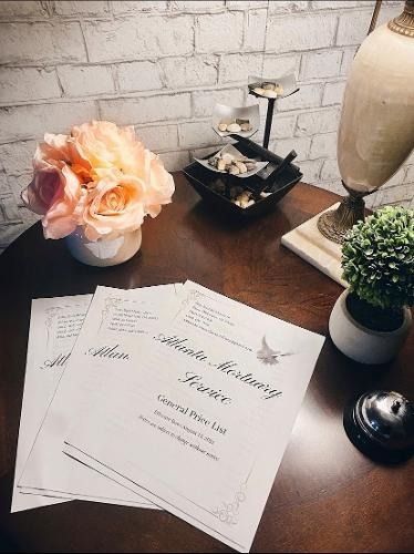 Wedding invitation suite on a wooden table with flowers, candle, and decorative items.