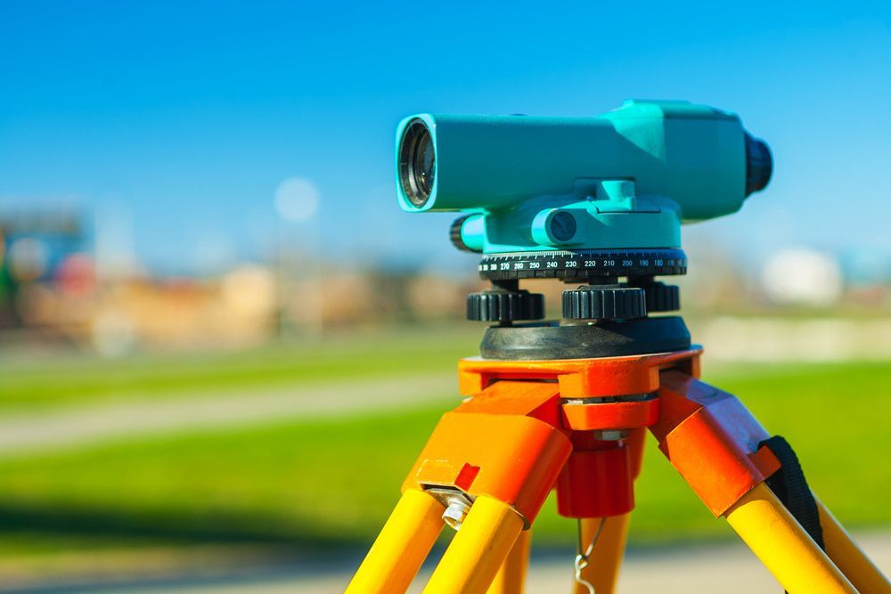 A Telescope Is Sitting On Top Of A Tripod In A Field  — CalCo Surveyors Pty Ltd in Gloucester, NSW