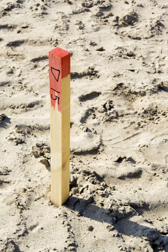 A Wooden Pole With The Number 7/15 On It — CalCo Surveyors Pty Ltd in Diamond Beach, NSW