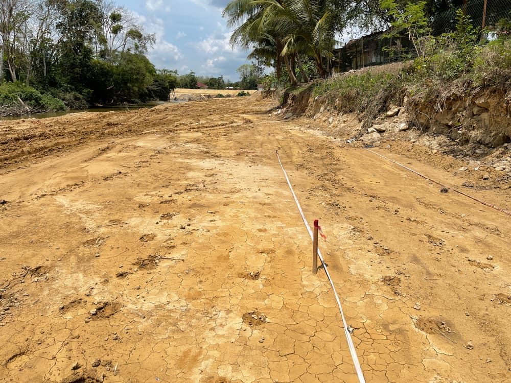 A Dirt Road With A White Line On It And Trees In The Background  — CalCo Surveyors Pty Ltd in Old Bar, NSW