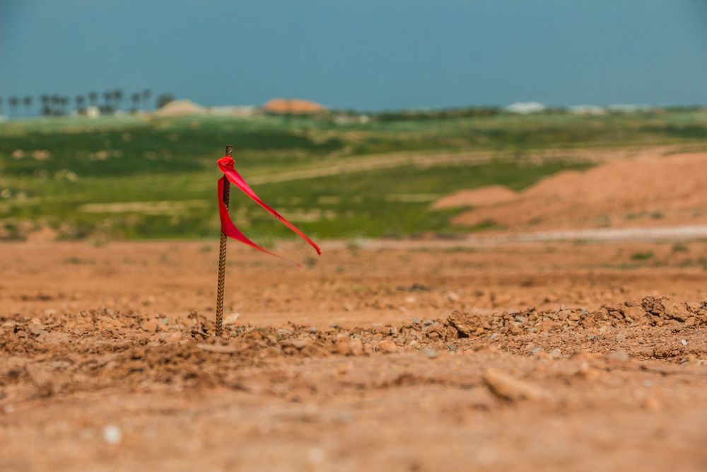 A Red Flag Is Stuck In The Middle Of A Dirt Field — CalCo Surveyors Pty Ltd in Wingham, NSW