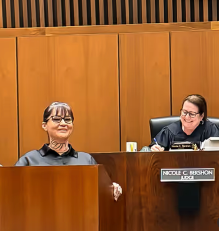 Two female judges are sitting at a podium in a courtroom.