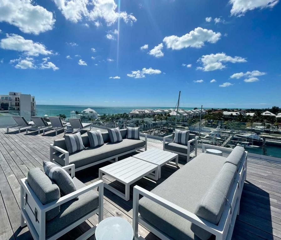 A patio with a view of the ocean and a couch and chairs
