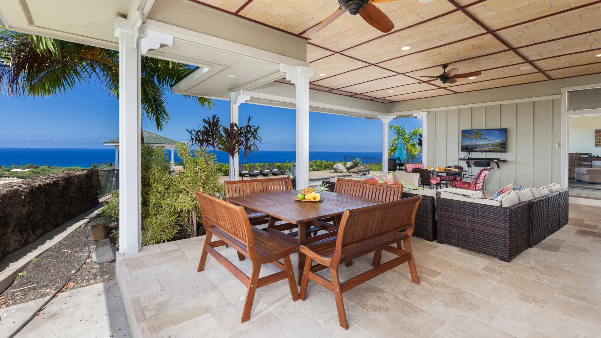 There is a table and chairs on the patio with a view of the ocean.