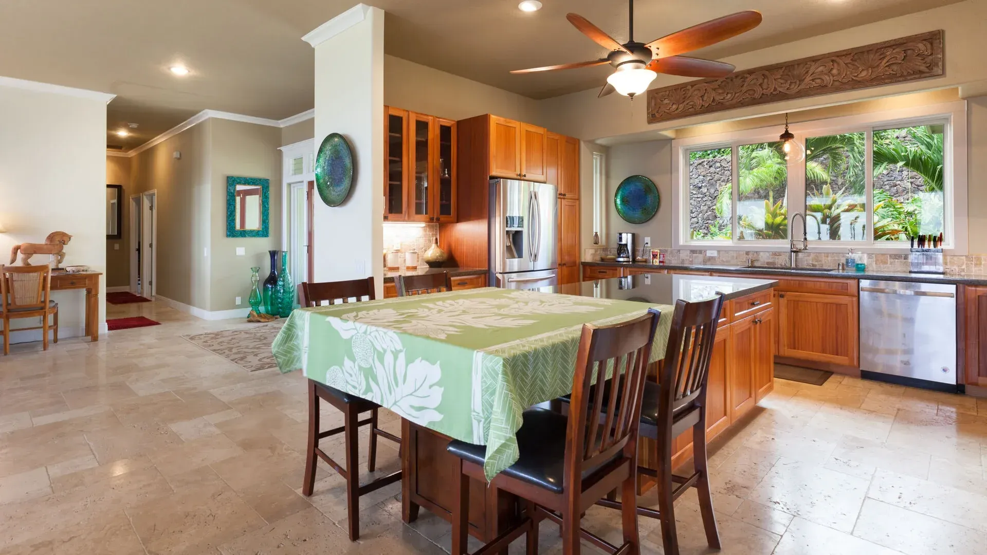 A kitchen with a table and chairs and a ceiling fan.
