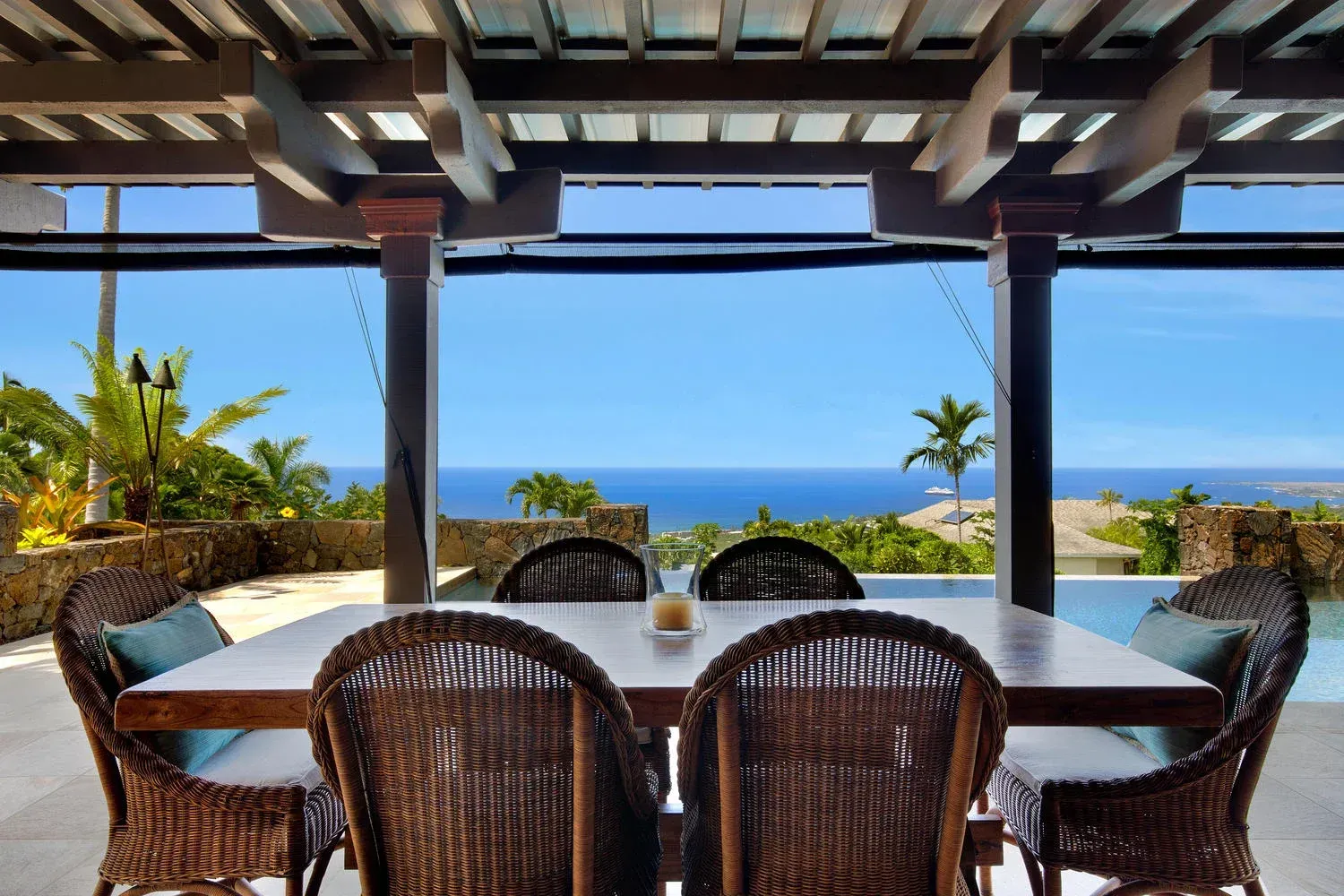 A dining room table and chairs with a view of the ocean