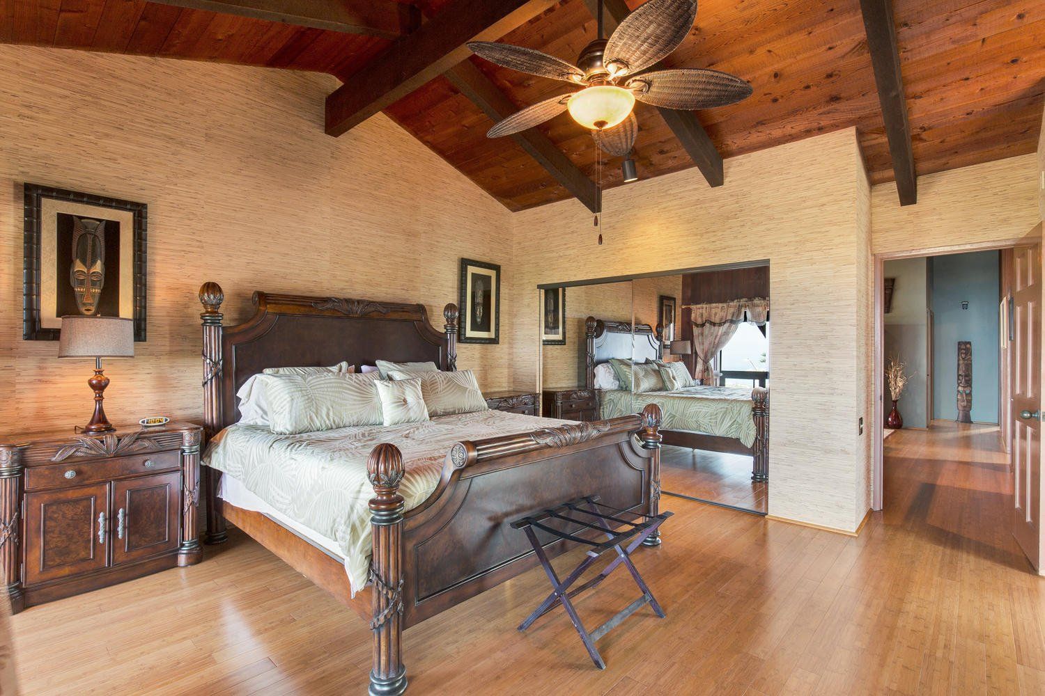 A bedroom with a large bed and a ceiling fan.