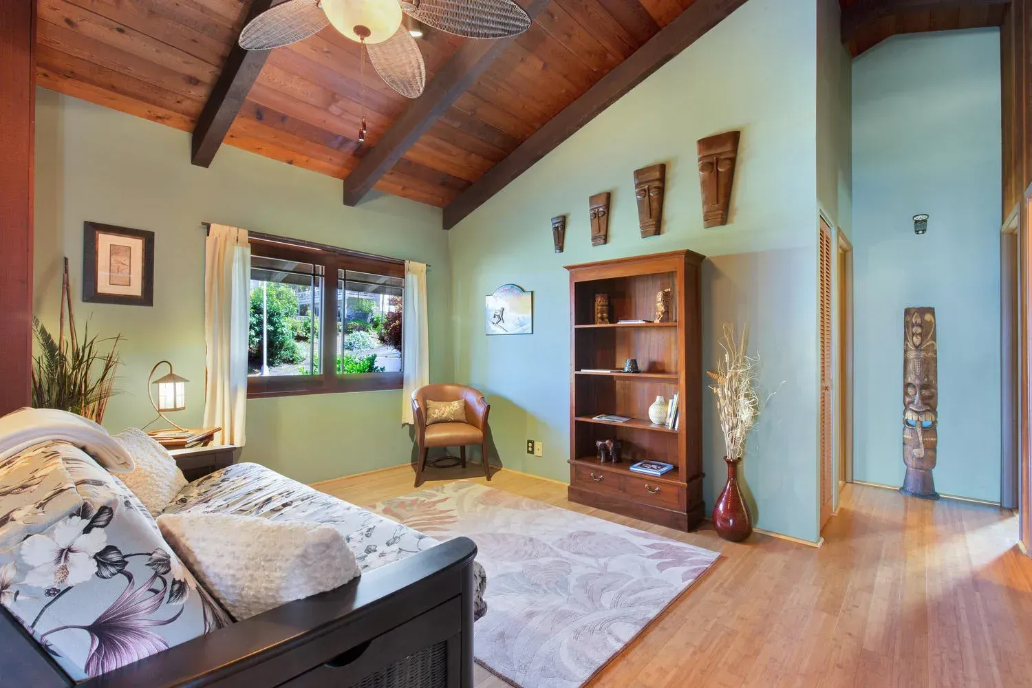 A living room with green walls and a ceiling fan