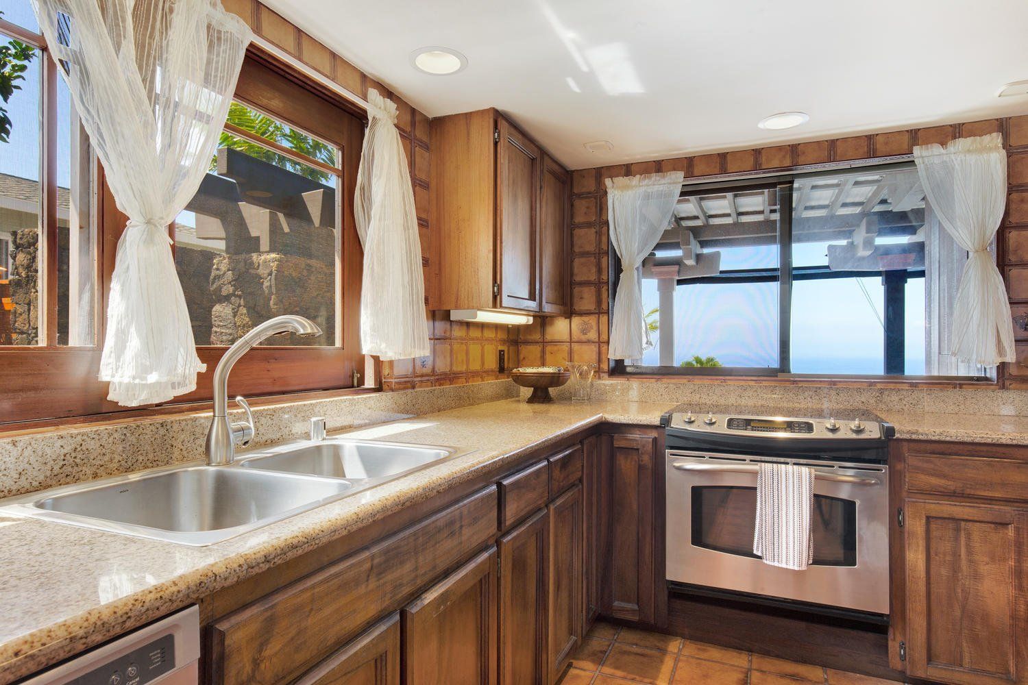 A kitchen with two sinks , a stove , and a window.