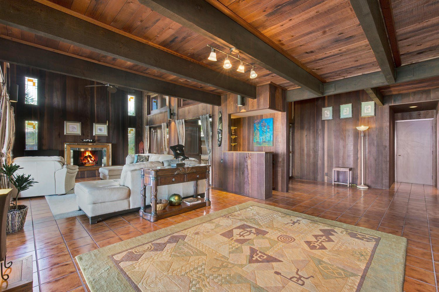 A living room with a rug on the floor and a fireplace.