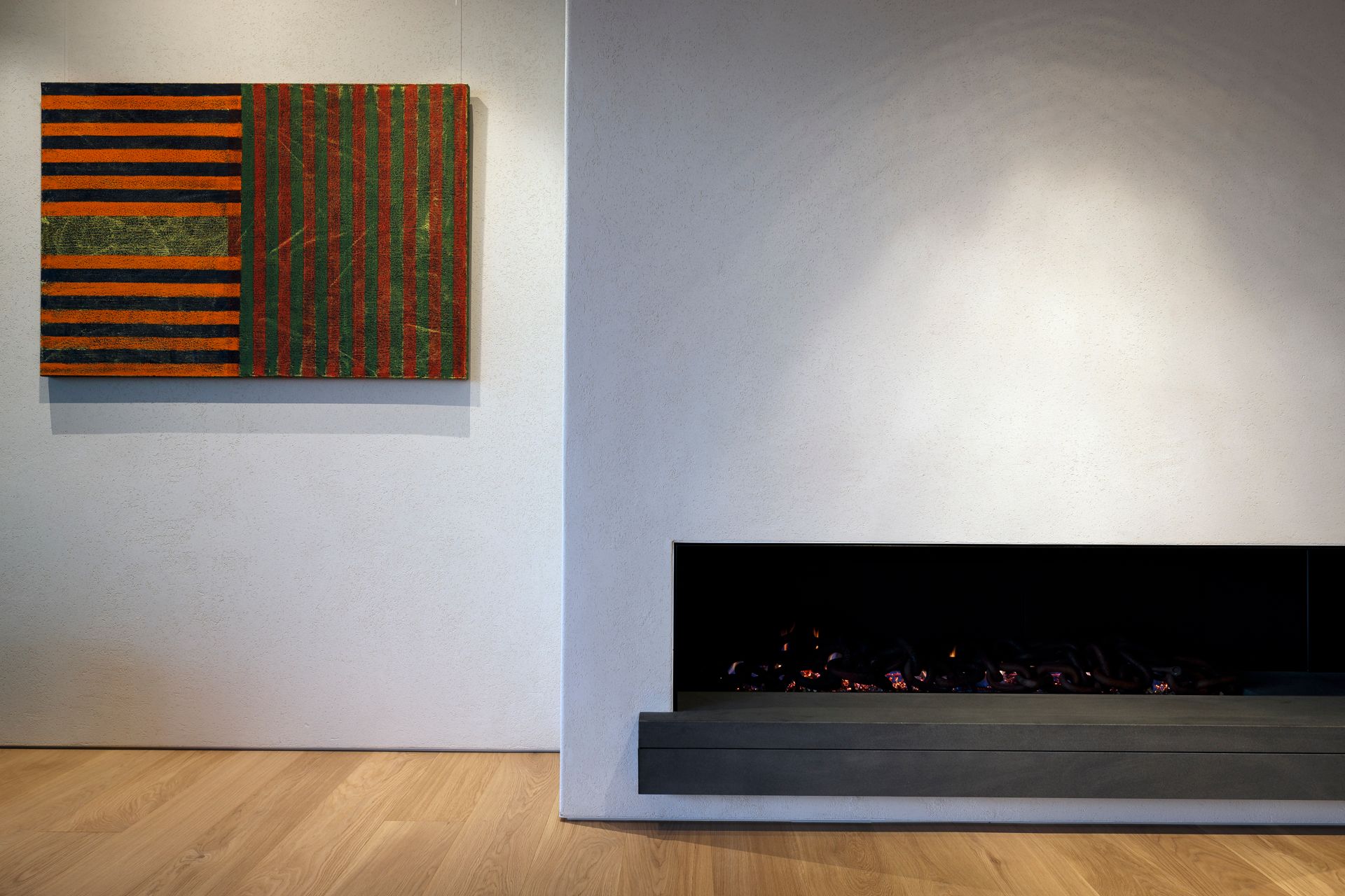 A living room with a fireplace and a painting on the wall.