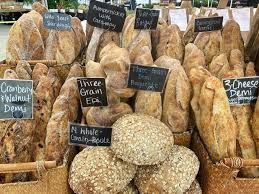 A bunch of different types of bread are sitting on top of each other on a table.