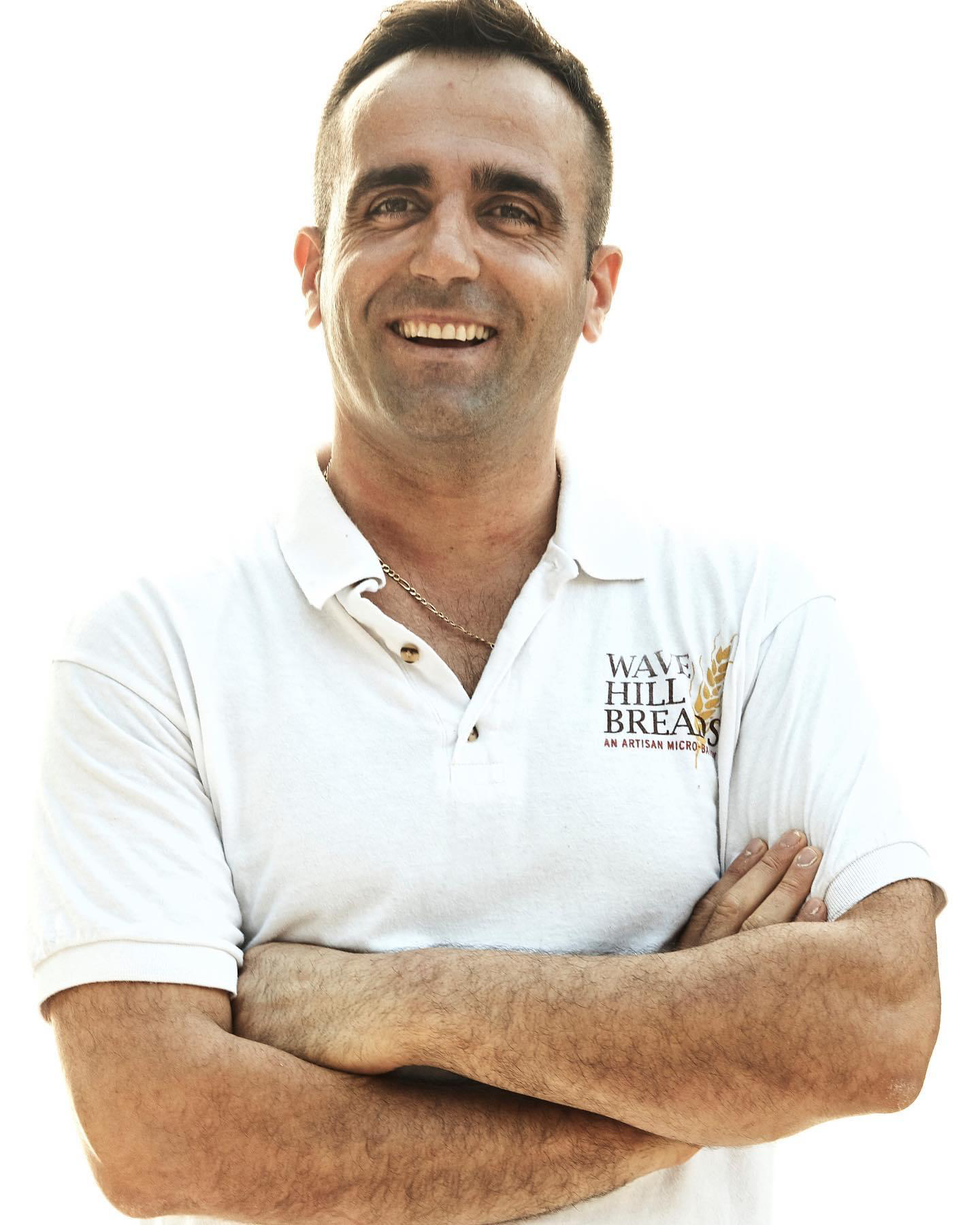 A man with his arms crossed wears a polo shirt that says jesus is the best