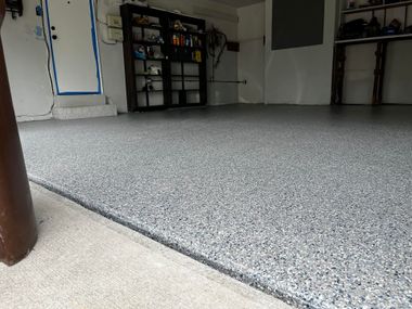 Worker boots walking across a glossy blue epoxy floor in a room under construction