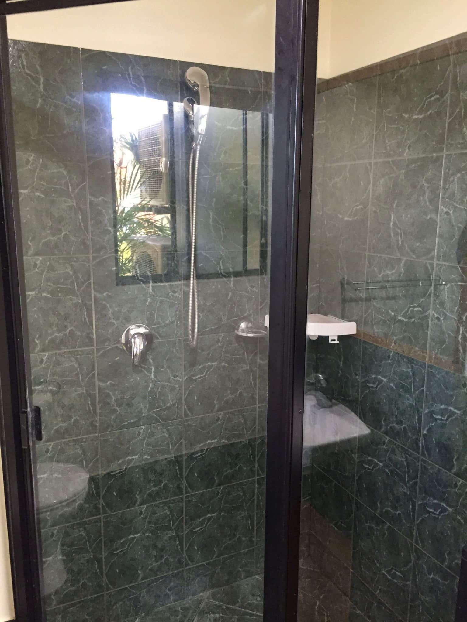 A Bathroom With a Walk in Shower, Toilet, Sink and Mirror — Pain in the Glass Window Cleaning in Airlie Beach, QLD