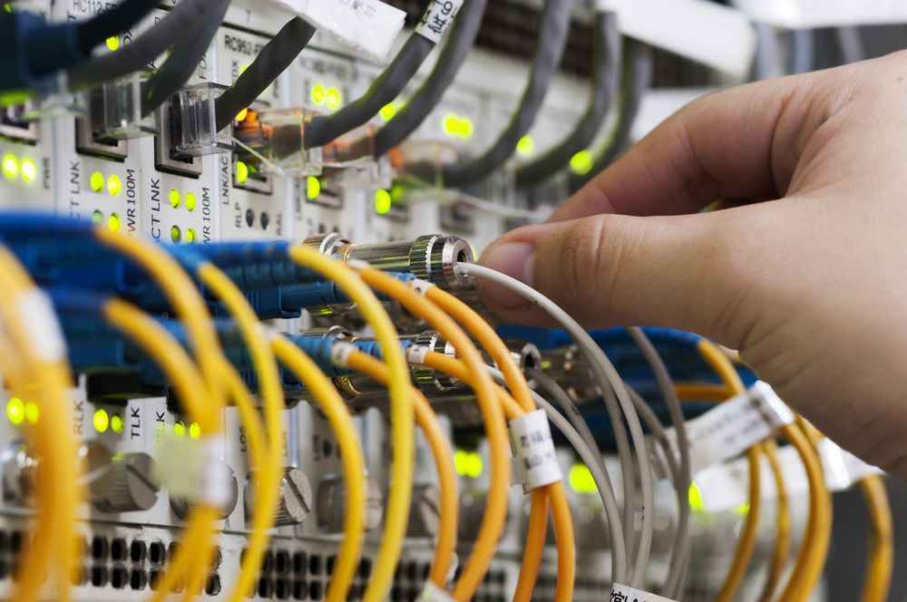Hands Connecting Network Cables in a Server Rack — Comms Cabling Central Coast In Kanwal, NSW