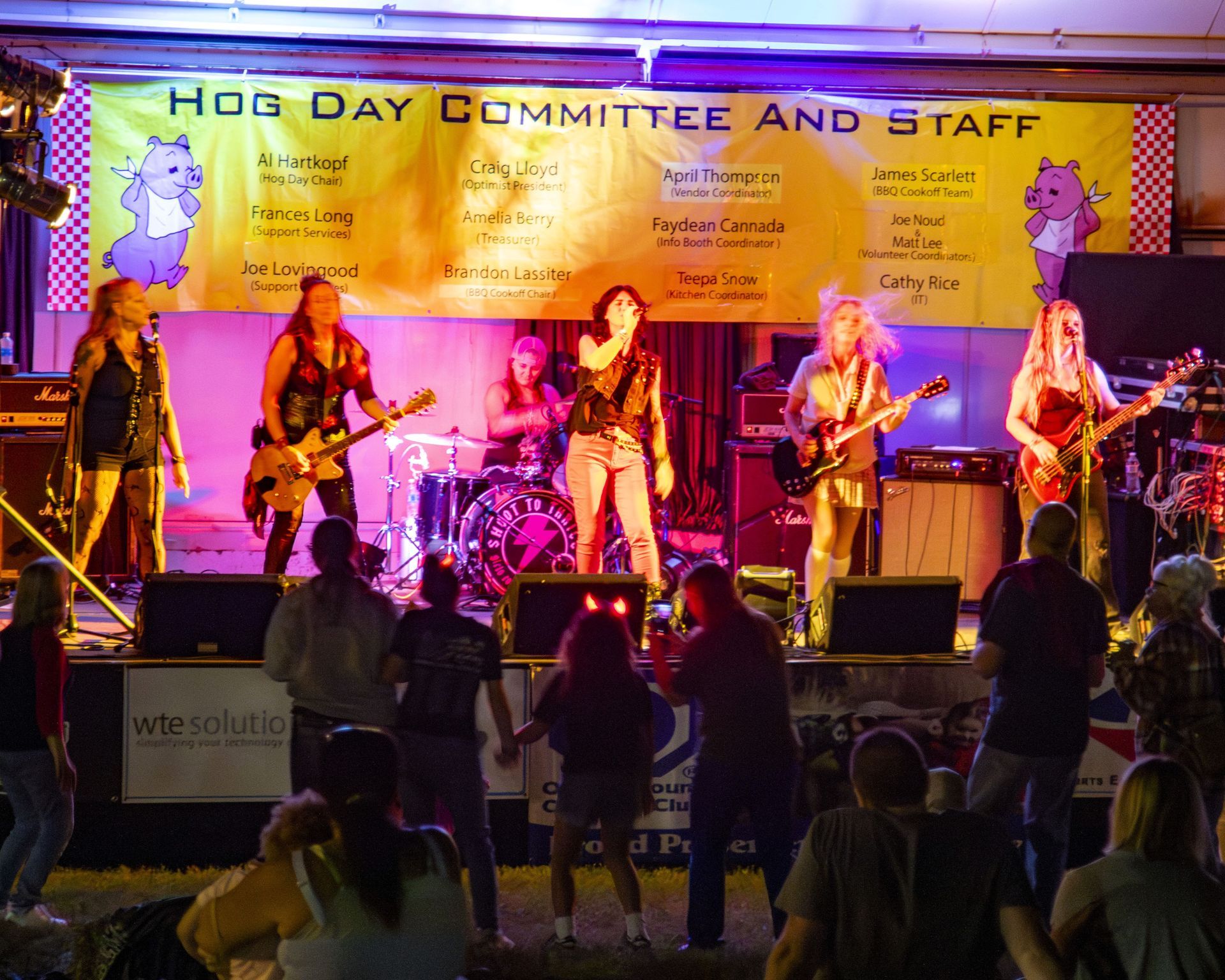 Live band performing on an outdoor stage under a “Hope Day Committee and Staff” banner, with audience silhouettes below.