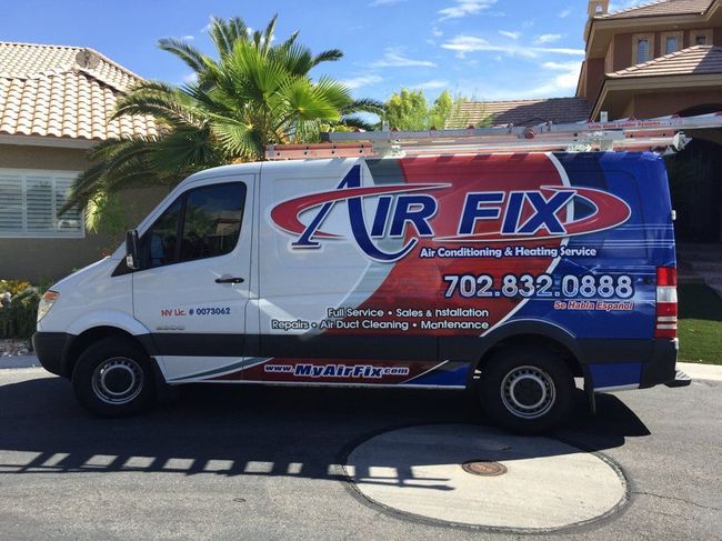 White Air Fix van parked on street; company logo and phone number on side.