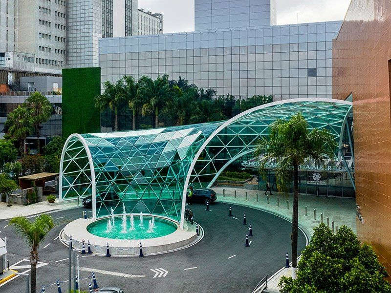 An aerial view of a large building with a fountain in front of it.