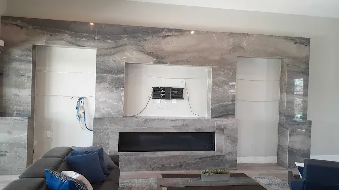 Living room with gray stone wall, fireplace, and TV mount; unfinished.