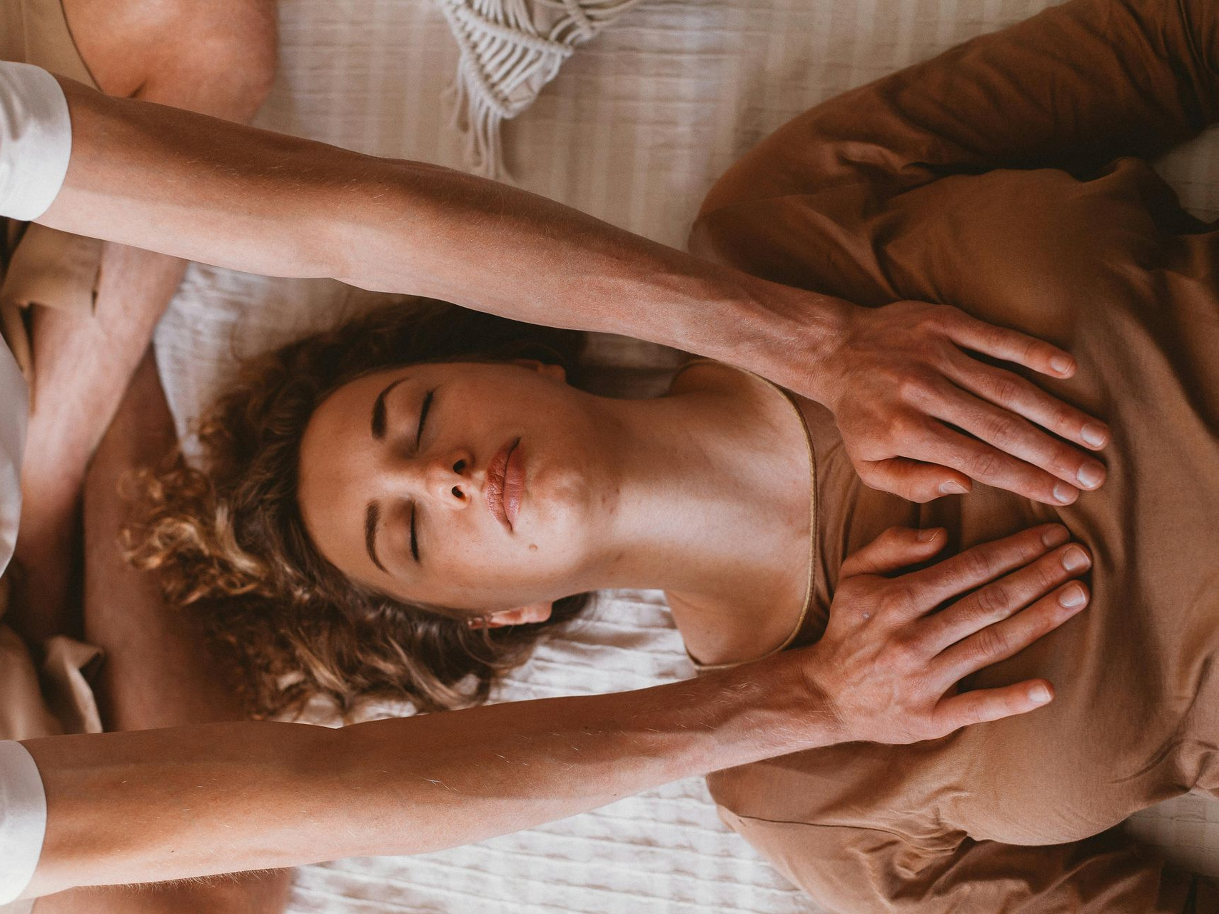 woman seated in the desert with  hands on heart and belly