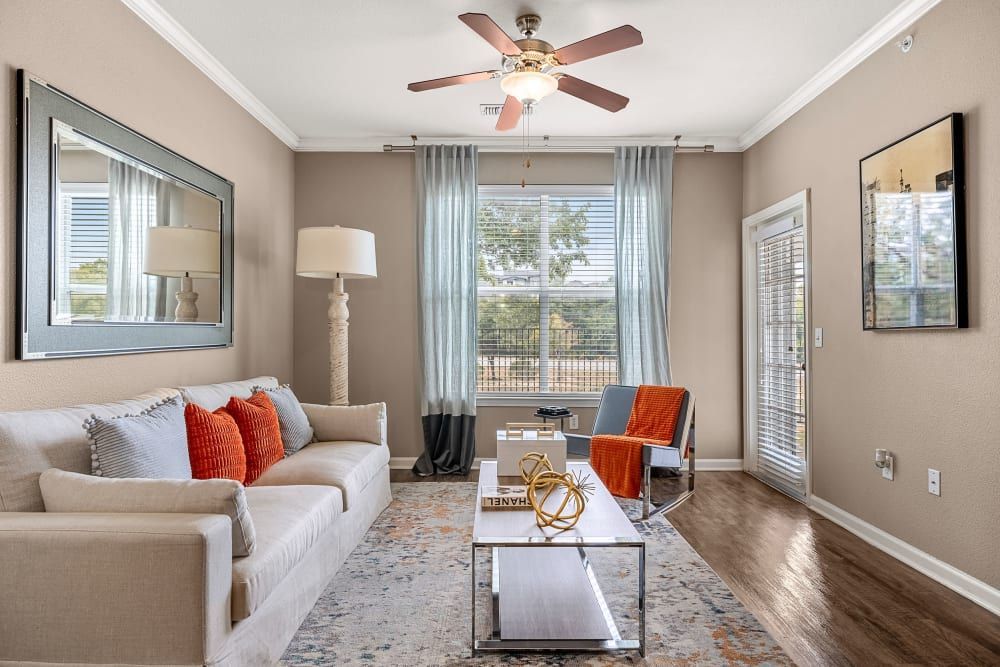 a living room with a couch, chair, coffee table, and ceiling fan at Marquis at Crown Ridge in San Antonio, TX.