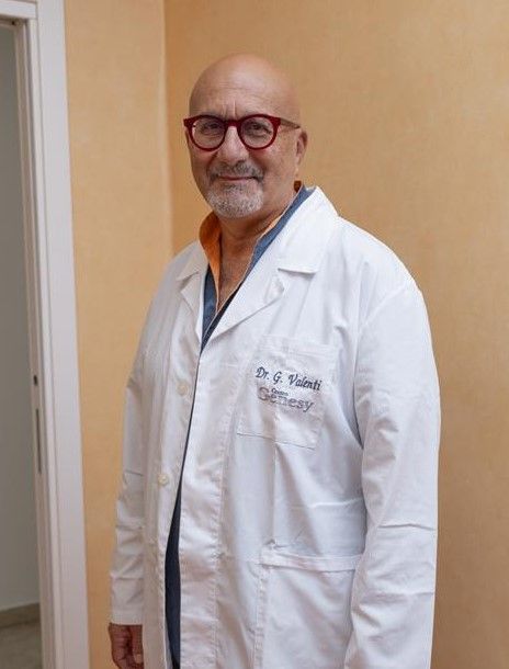 Fuori c'è un uomo calvo con un camice bianco e occhiali da sole. Sul camice sono ricamati