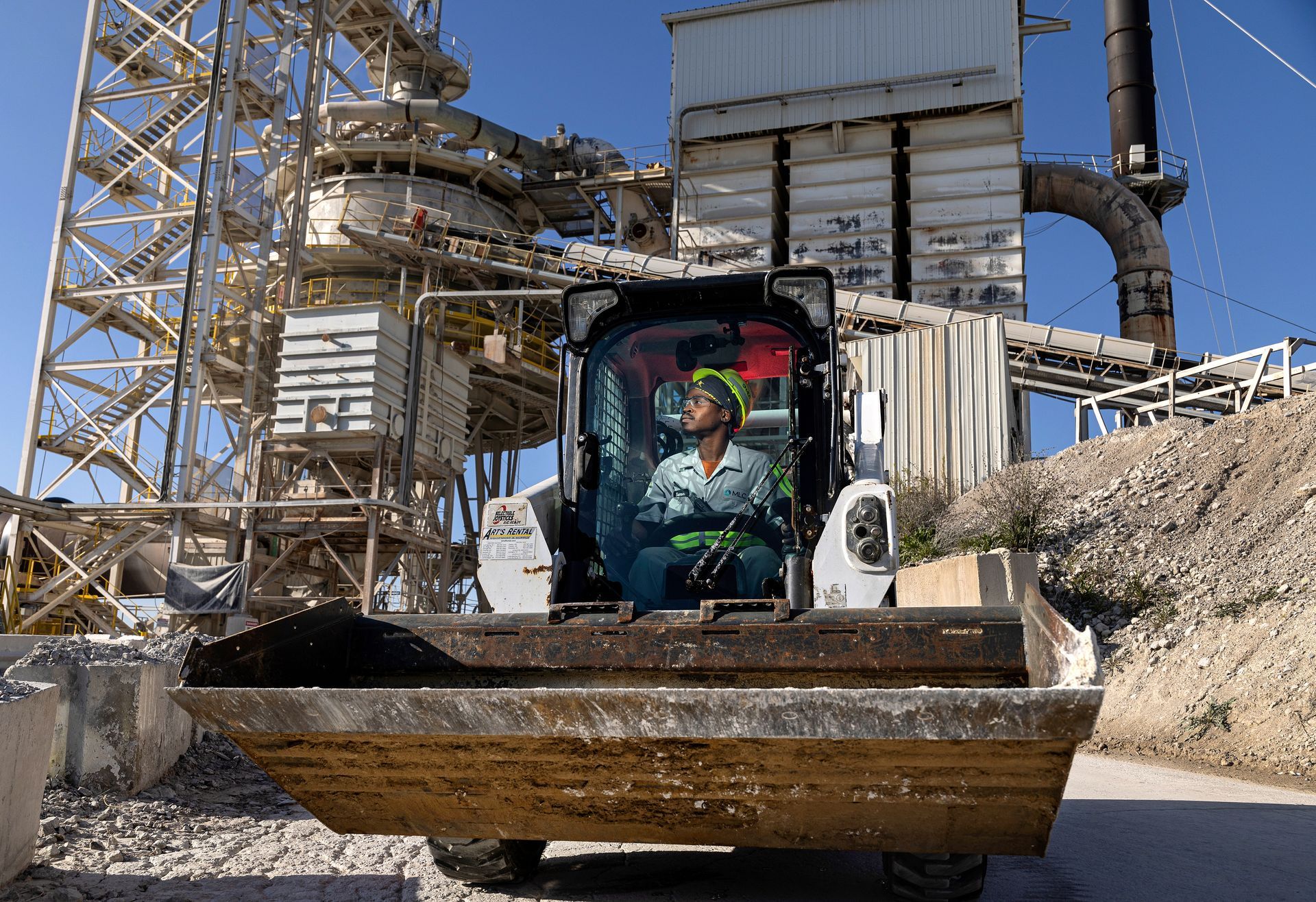 Heavy equipment operator managing industrial earth moving equipment in manufacturing facility.