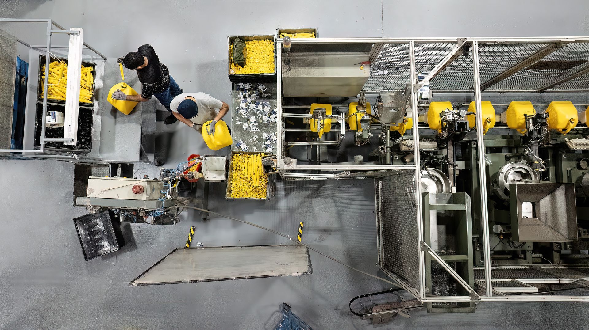 An employee inspects products being made in a manufacturing facility. The photo was taken using a drone inside of the facility. 
