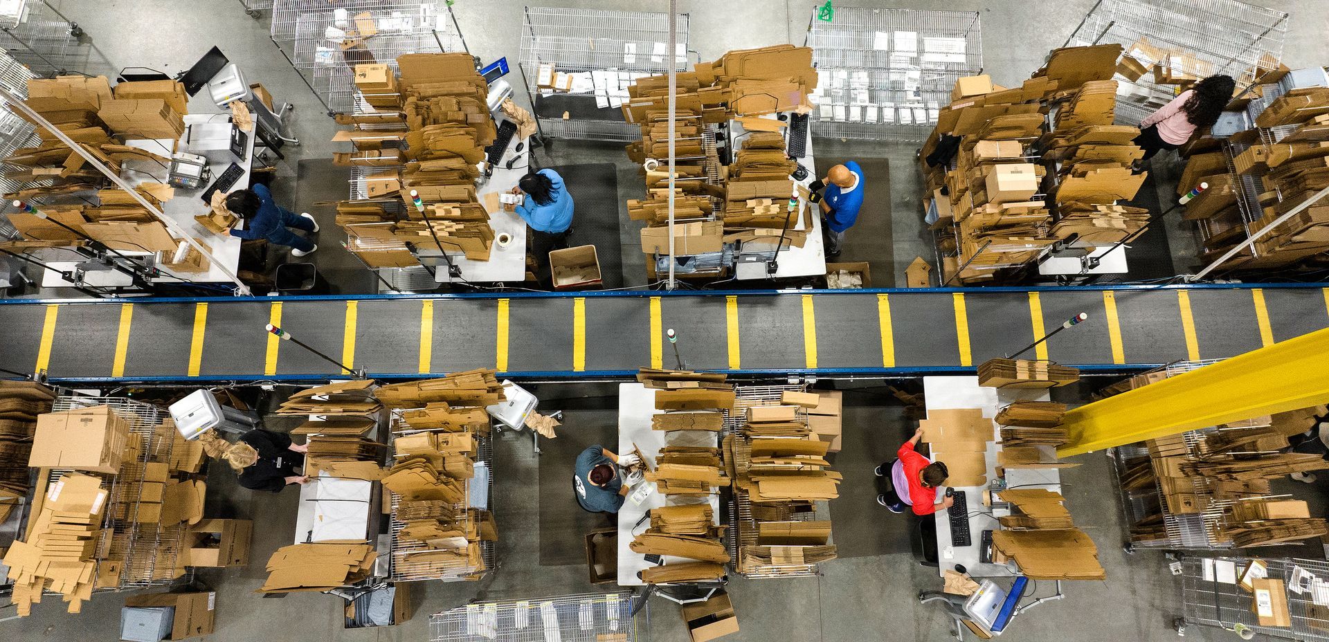 Overhead photo taken using a drone of workers on an assembly line in a manufacturing facility. 