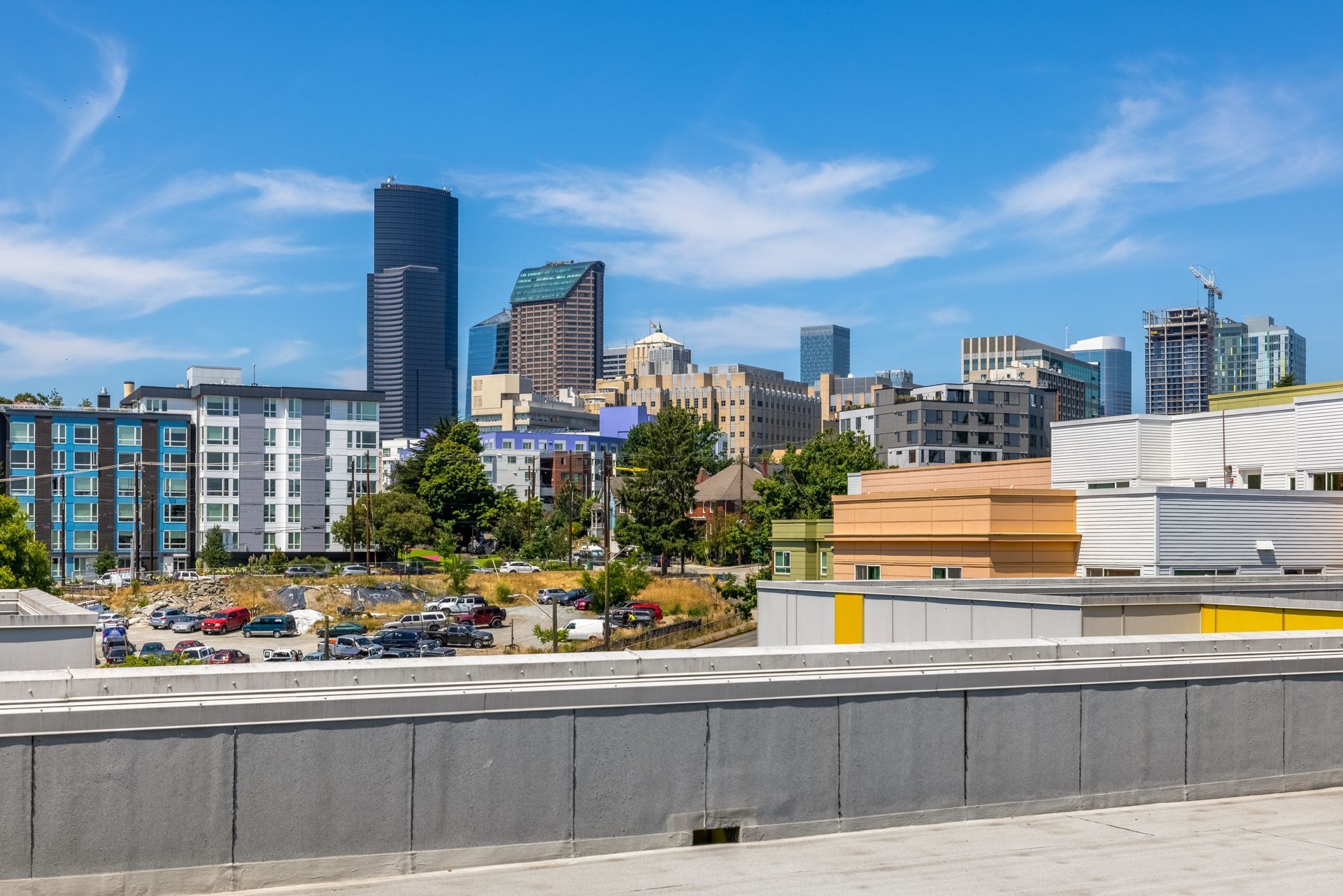 City skyline with modern high-rises under a blue sky, viewed from a rooftop or terrace at Anthem on 12th, offering luxury apartments in Capitol Hill.