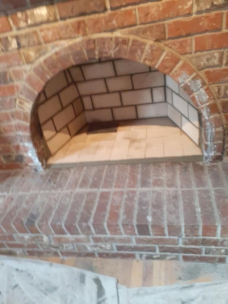 Brick fireplace with arched opening and tiled firebox interior