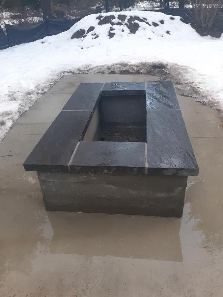 Rectangular black metal fire pit in a snowy outdoor area