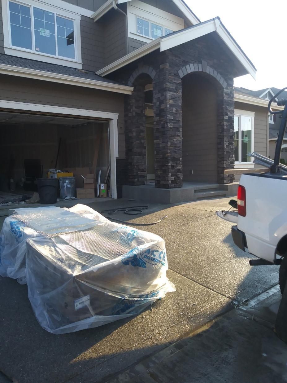 Pickup truck and wrapped furniture outside a house with an open garage, on a sunny day
