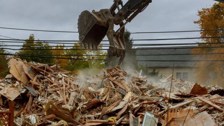 A pile of rubble is being cleared by a bulldozer