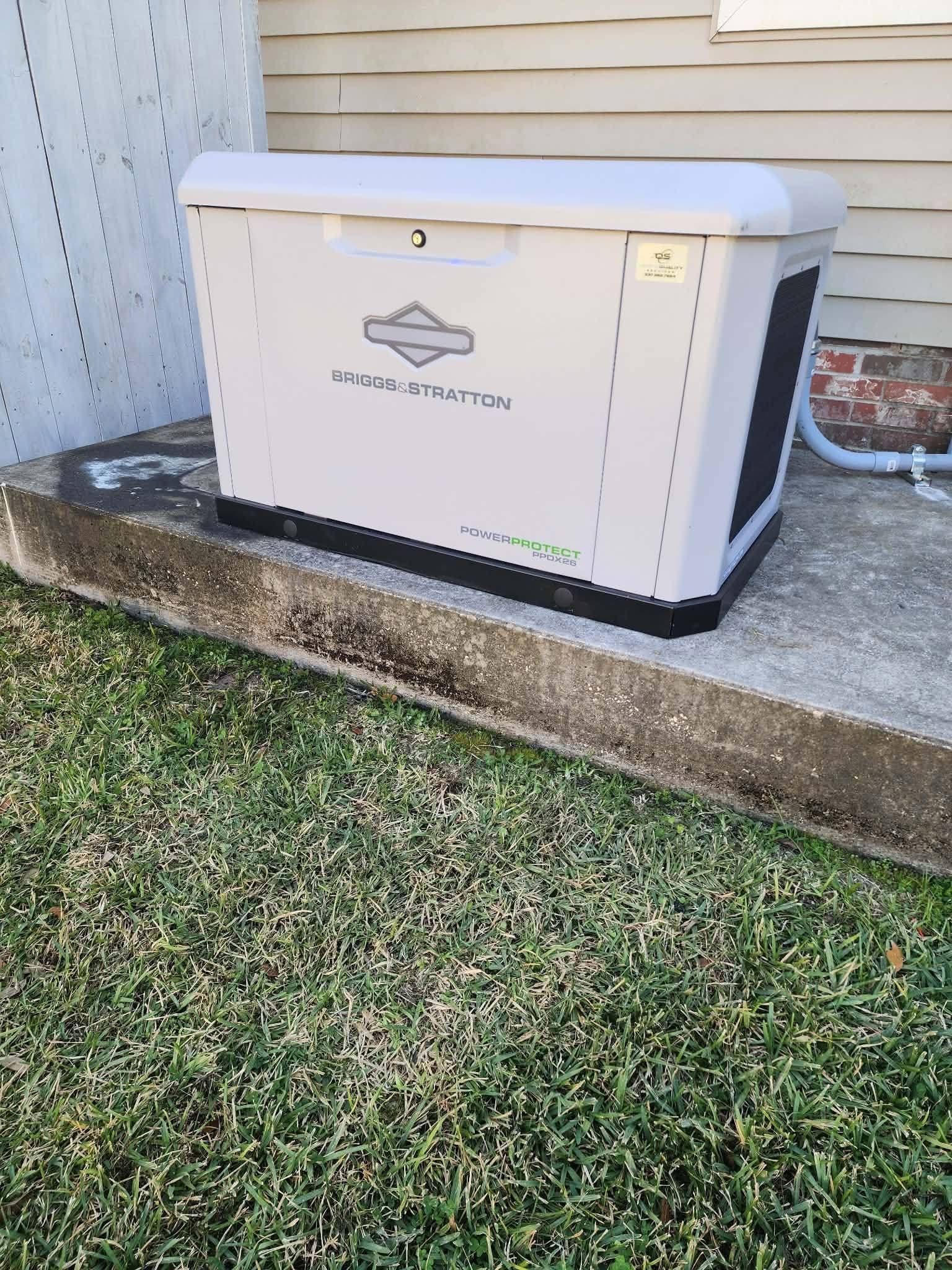 White Generac home standby generator beside a house on a concrete pad near grass
