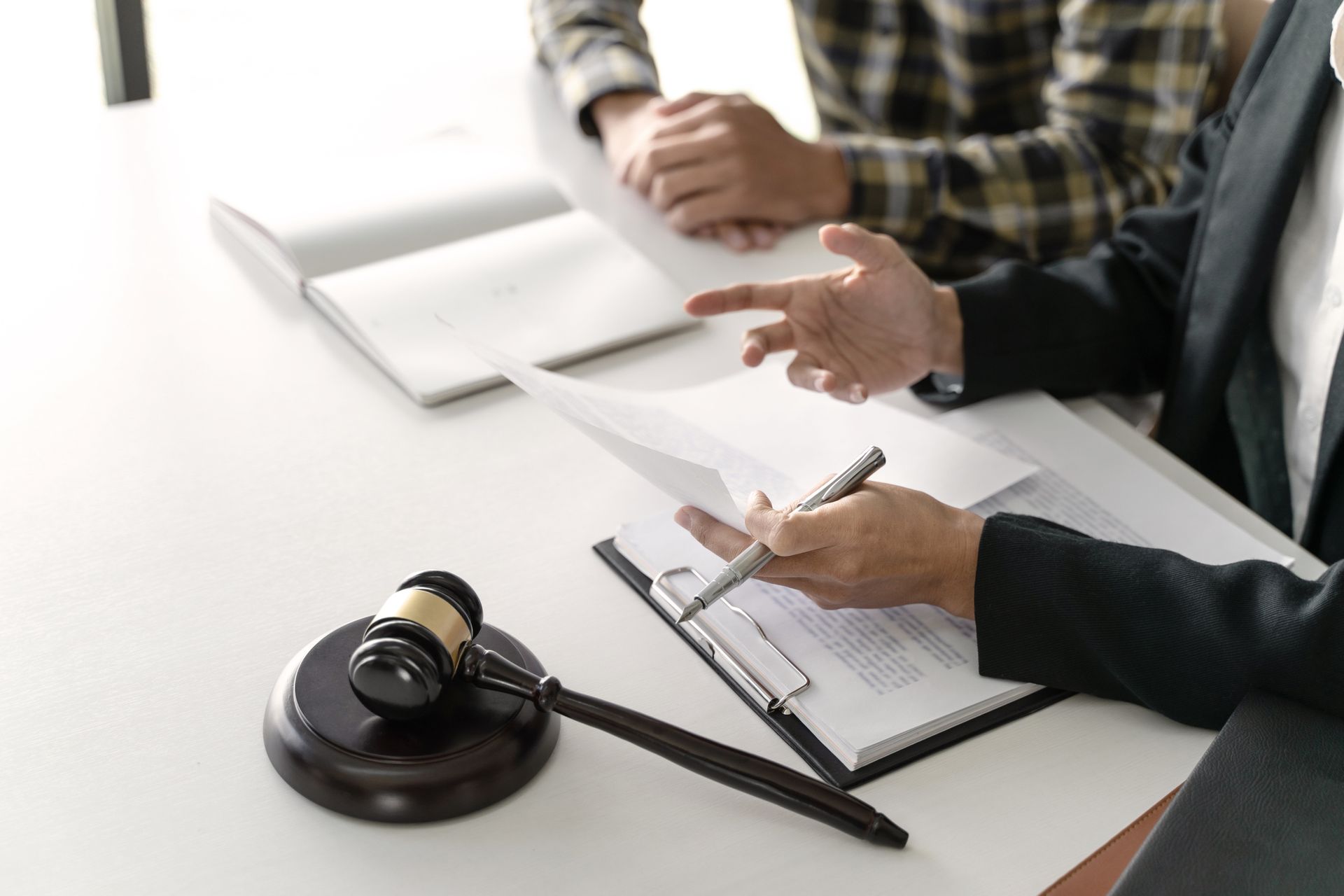 Cropped view of a criminal lawyer and their client during a legal consultation.