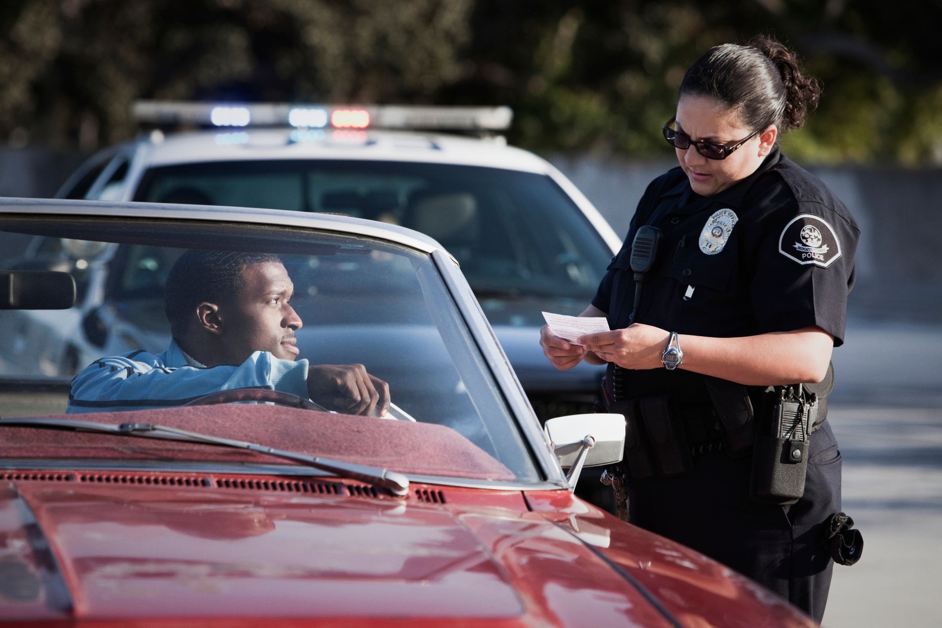 Policewoman checking paperwork of man in convertible in Mocksville, NC, by The Law Offices of Richard McCain Policewoman checking paperwork of man in convertible in Mocksville, NC, by The Law Offices of Richard McCain