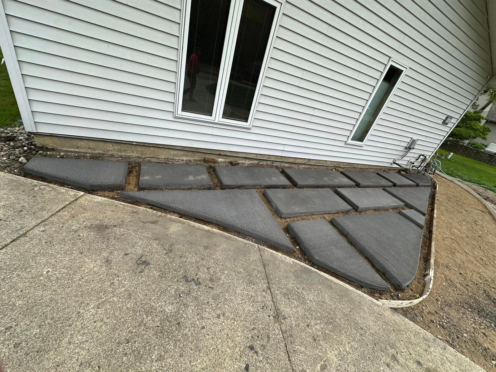 A concrete sidewalk is being built in front of a mobile home.