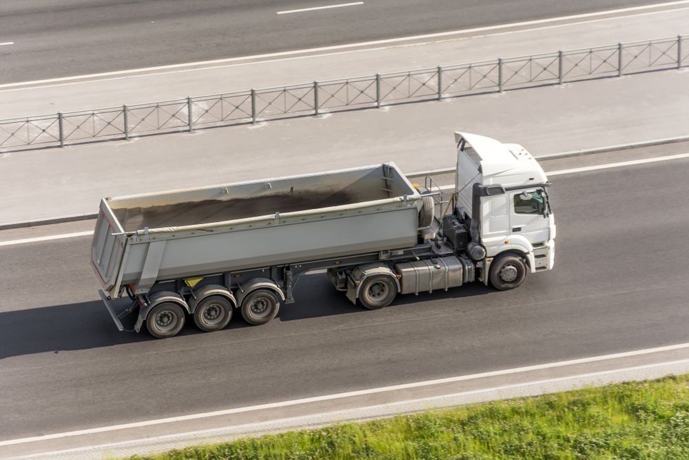 A Dump Truck Is Driving Down a Highway — ZBM Constructions in Wollongbar, NSW