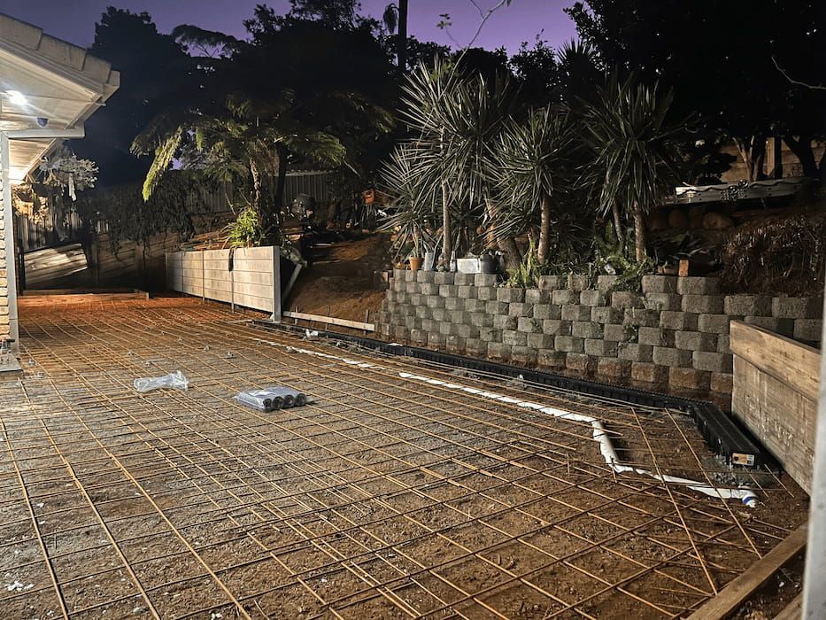 A Concrete Driveway Is Being Built in Front of A House at Night — ZBM Constructions in Ballina, NSW