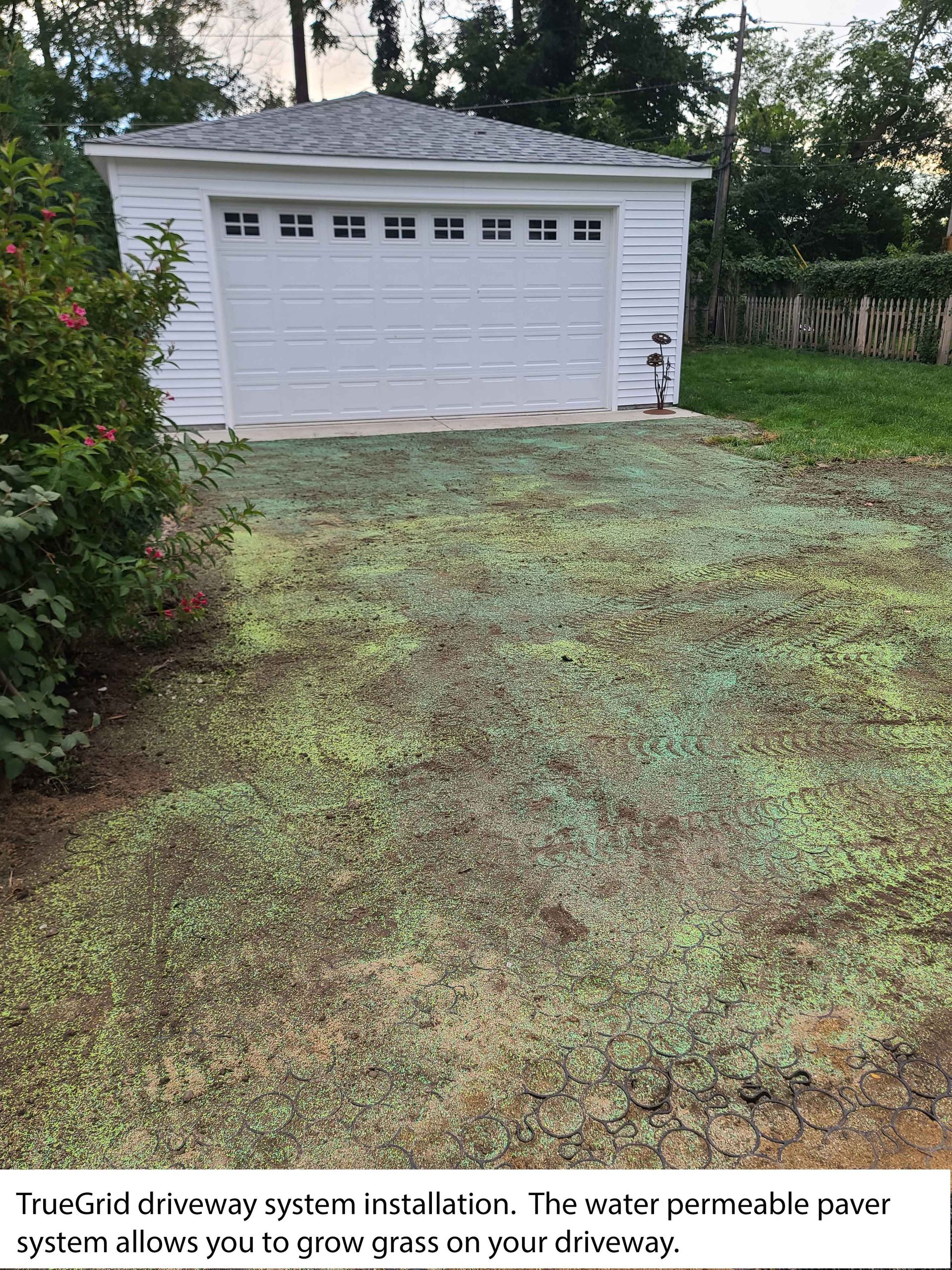 Driveway with green permeable pavers in front of a white garage.