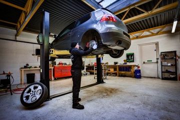 mechanic repairing car's tire in repair shop